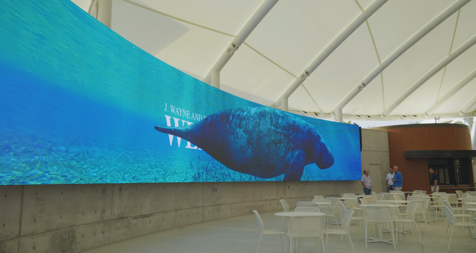 Stunning 65‑foot curved DVLED video wall displaying a manatee swimming past welcome message.